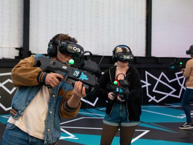 Work Christmas party ideas: colleagues playing free roam VR under fairy lights